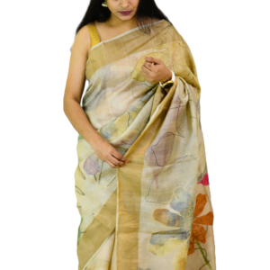 Hand-painted beige saree with delicate floral motifs, draped elegantly by a woman, showcasing artistic craftsmanship and minimalistic elegance